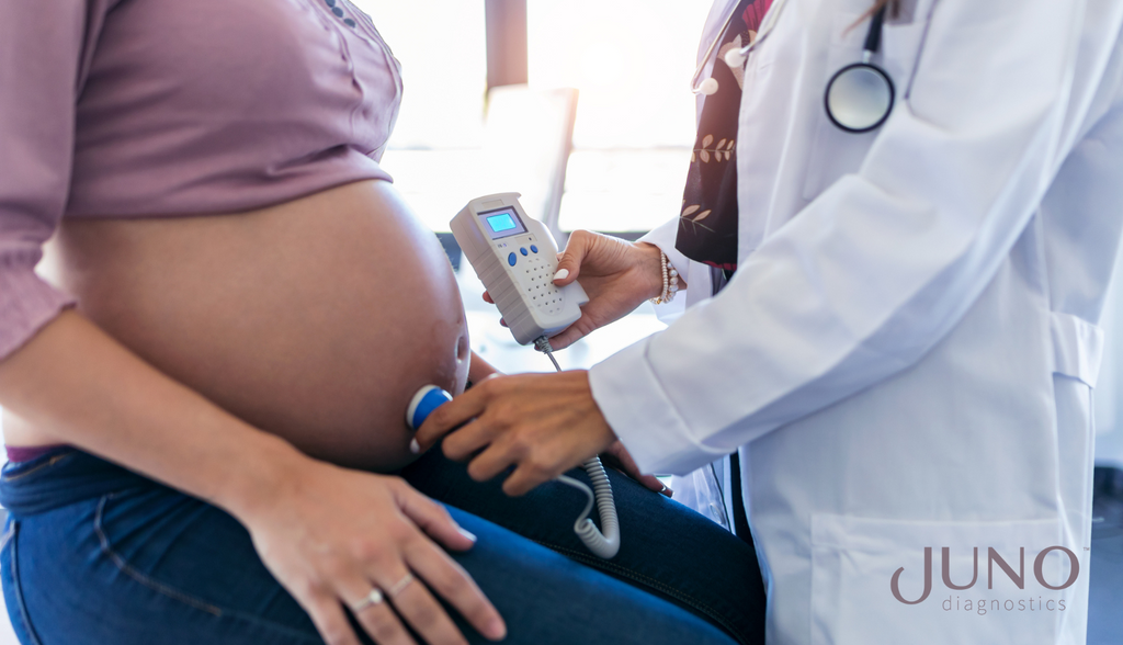 Obstetrician gynecologist performing Doppler auscultation in expecting mother, checking blood flow in placenta and uterus