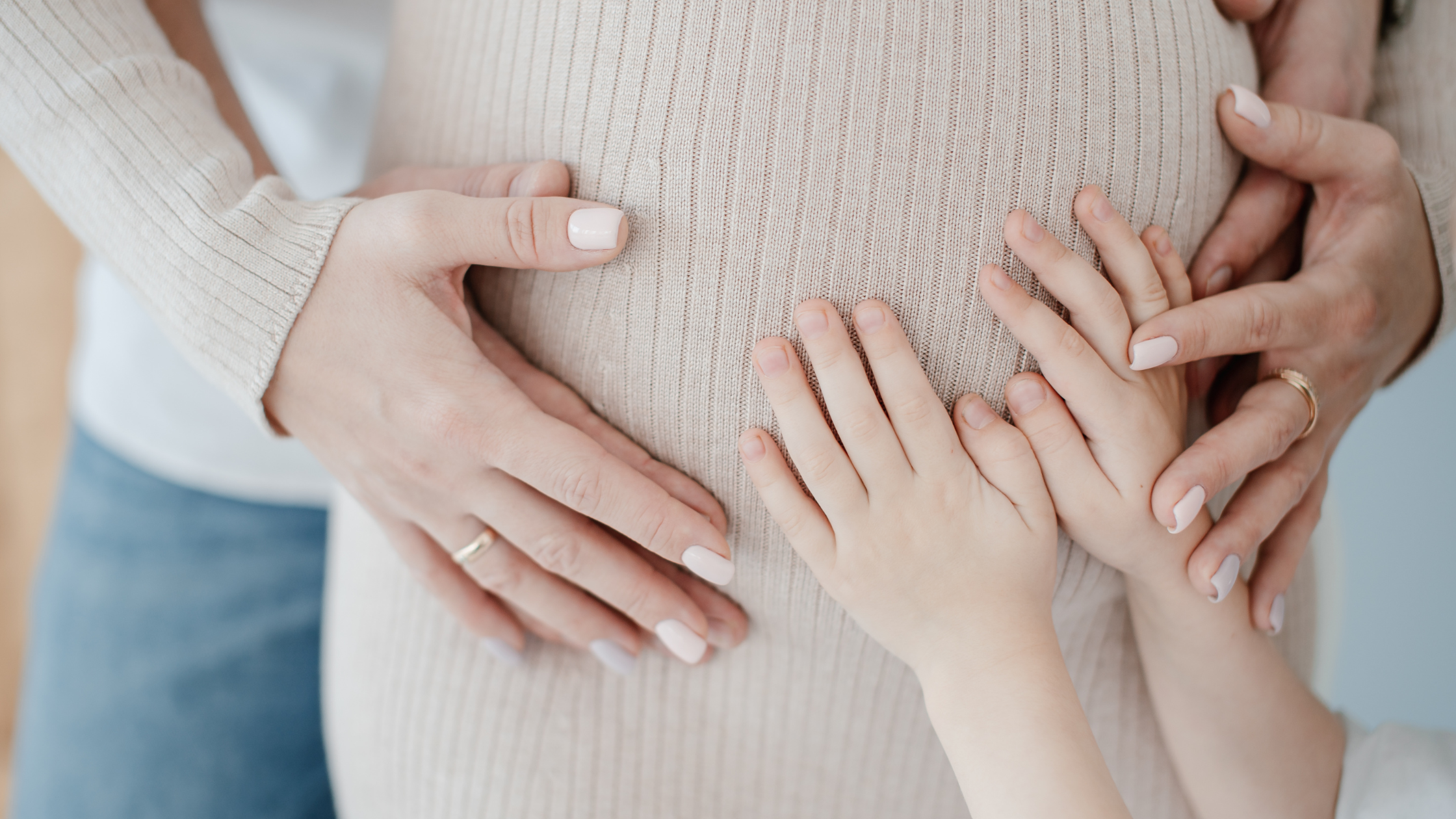 Hands on a pregnant mother's belly honoring Mother's Day