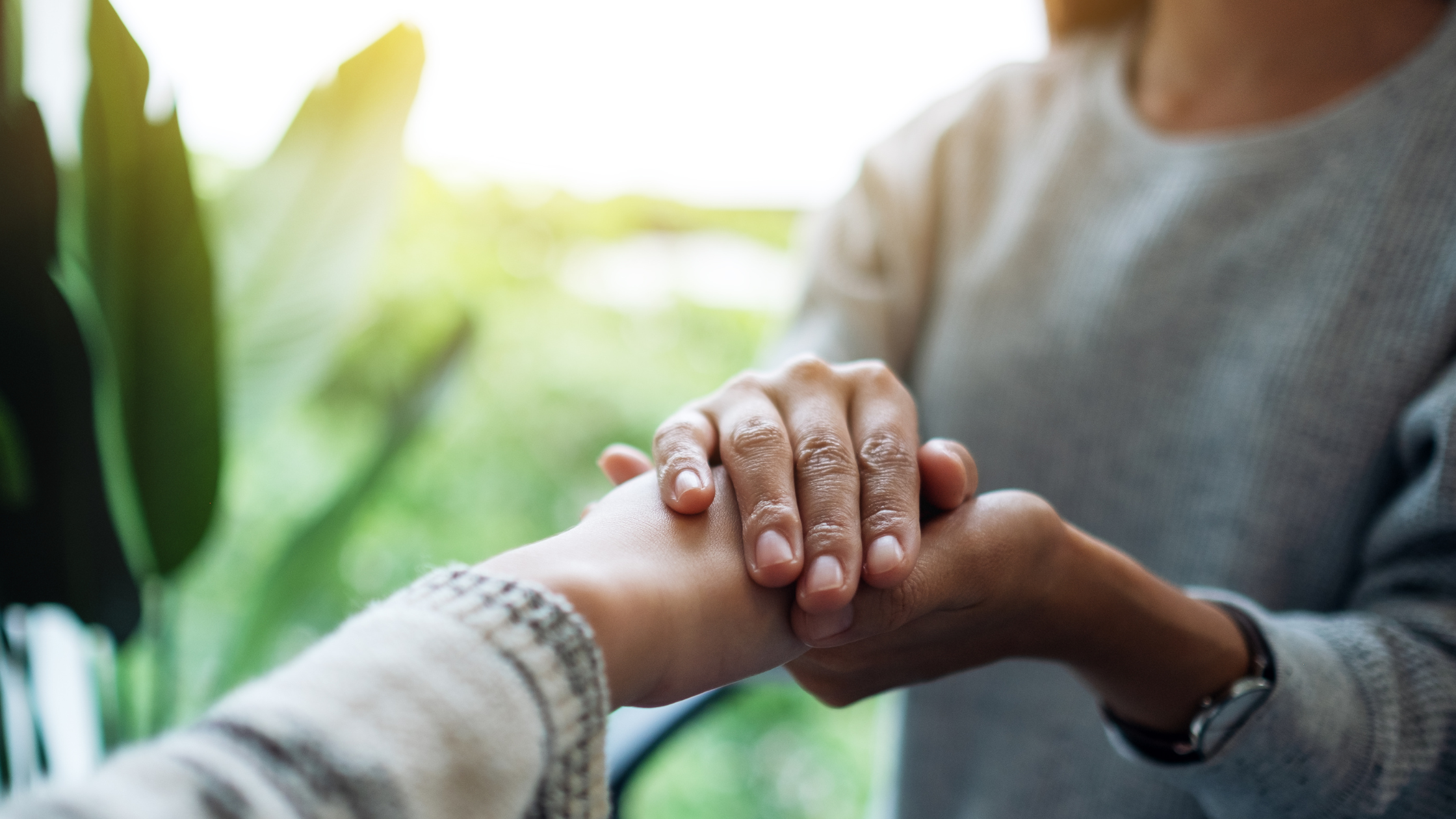 two women holding hands representative of the surgacy experience  